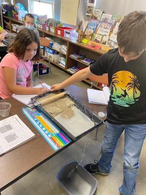 students observing erosion experiment